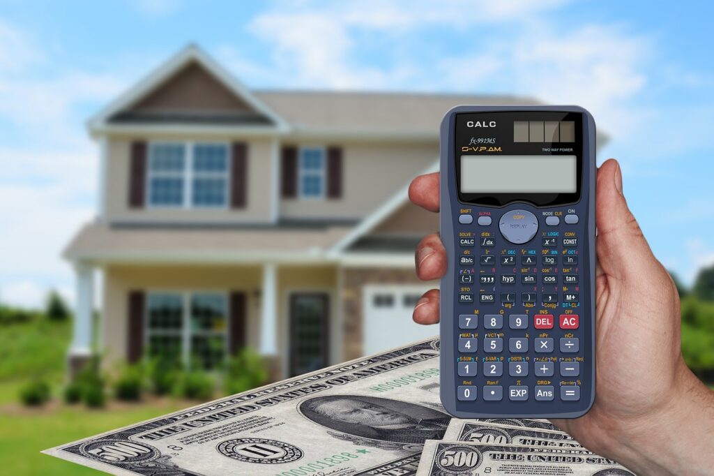 calculator and money in front of a house